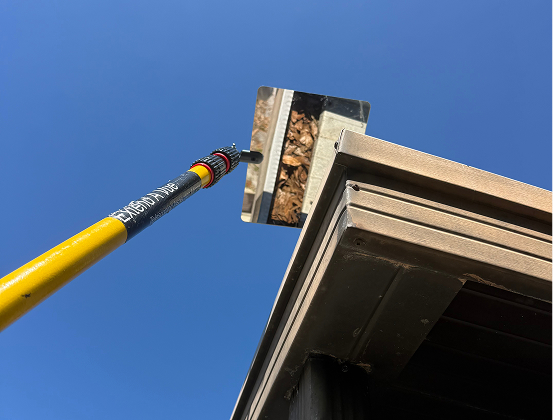 man-cleaning-autumn-leaves-from-roof-gutter
