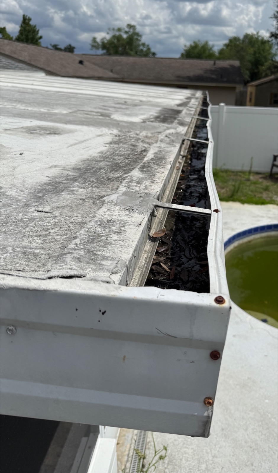 Debris-filled built-in gutter before leaf guard installation in Altamonte Springs